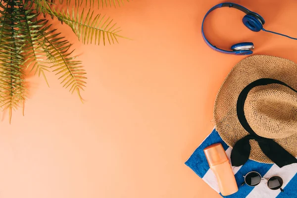 Top View Summer Accessories Headphones Sunscreen Orange Background Palm Leaves — Stock Photo, Image