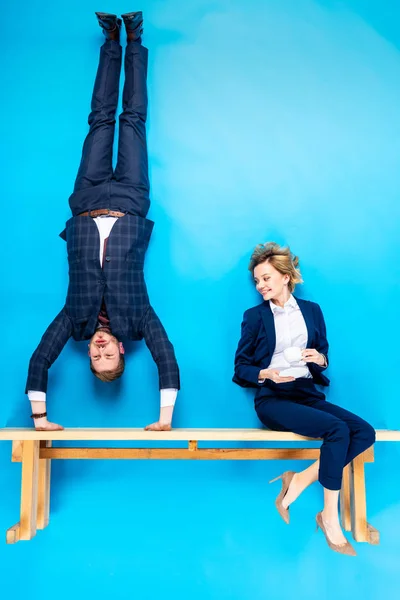 Sorrindo Casal Elegante Posando Com Banco Madeira Fundo Azul — Fotografia de Stock