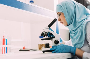 kopya alanı ile kimyasal laboratuvar deney sırasında mikroskop seyir kadın Müslüman bilim adamı