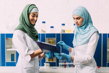 kadın Müslüman bilim adamları hijab kimyasal laboratuvar deney sırasında Pano holding