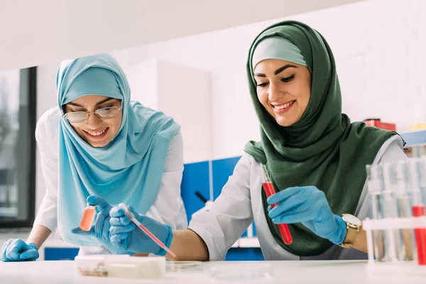 Lachende Vrouwelijke Islamitische Wetenschappers Hijab Met Reageerbuis Pipetteer Tijdens Experiment — Stockfoto