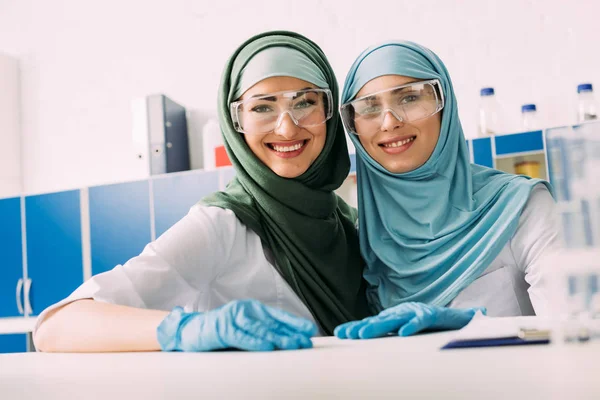 Mujeres Químicas Musulmanas Sonrientes Con Gafas Protectoras Hijab Mirando Cámara — Foto de Stock