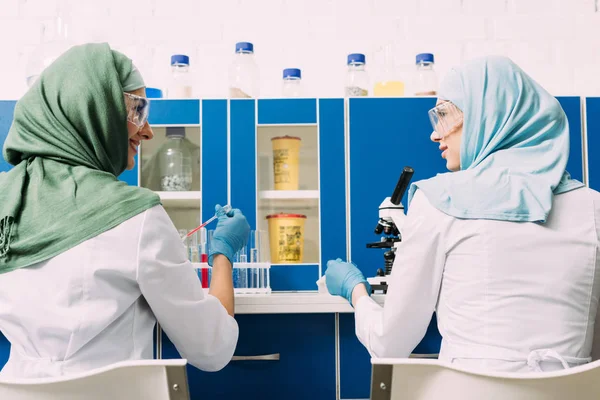 Vista Posterior Científicos Musulmanes Femeninos Usando Pipeta Microscopio Laboratorio Químico — Foto de Stock