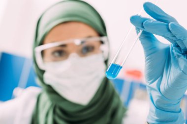 laboratuarda test tüpü tutan kadın Müslüman bilim adamı
