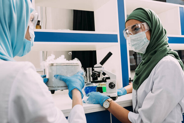 мусульманские ученые экспериментируют с микроскопом и сухим льдом в химической лаборатории

