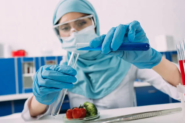 Mujer Musulmana Científica Sosteniendo Tubos Ensayo Durante Experimento Con Vegetales —  Fotos de Stock