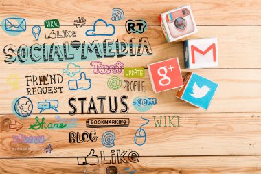 top view of cubes with google plus, gmail, instagram and twitter logo on wooden table with social media illustration clipart