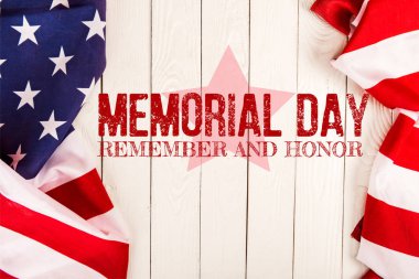 top view of american flags and memorial day lettering on white wooden surface clipart