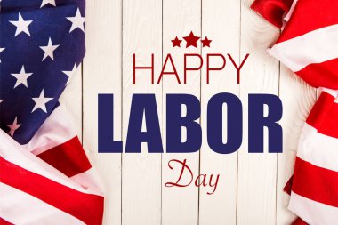 Amerikan bayrakları ve mutlu İşçi Bayramı yazı Beyaz ahşap yüzeyde Üstten Görünüm