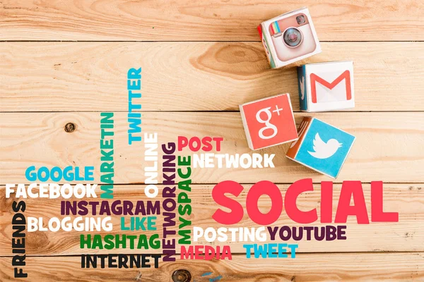顶部的块与谷歌加 Gmail Instagram 和推特标志的木桌上的顶部视图与社交媒体的插图 — 图库照片