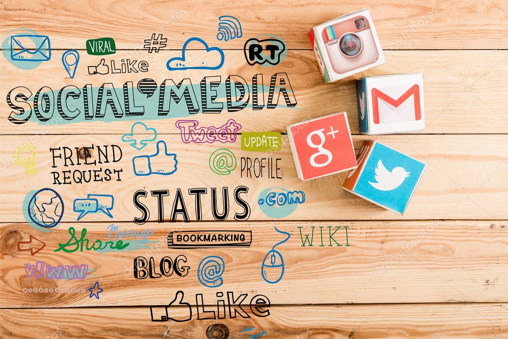 Top view of cubes with google plus, gmail, instagram and twitter logo on wooden table with social media illustration