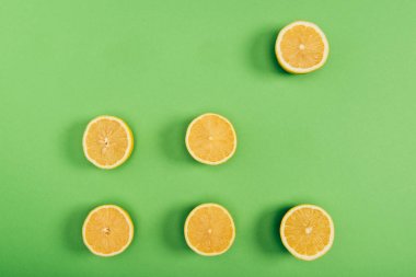 Renkli yeşil arka plan üzerinde sulu ve sarı kesim limon üst görünümü