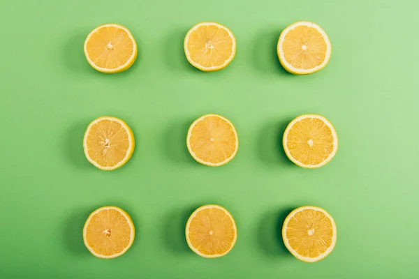 Вид Сверху Свежих Желтых Срезанных Лимонов Цветном Зеленом Фоне — стоковое фото
