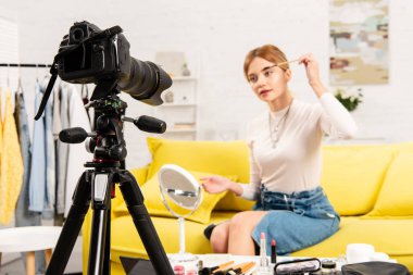 denim etek güzellik blogger seçici odak video kamera önünde kaşlar yapıyor