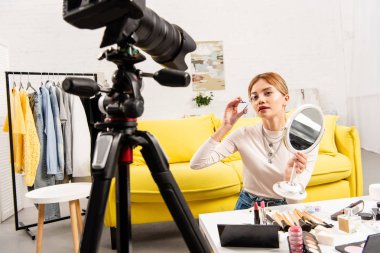 güzellik blogger ekran kamera önünde ayna tutan ve kıvırma kirpikler