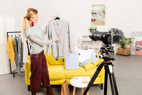 Blogueur Souriant Montrant Des Vêtements Devant Caméra Vidéo Maison — Photo