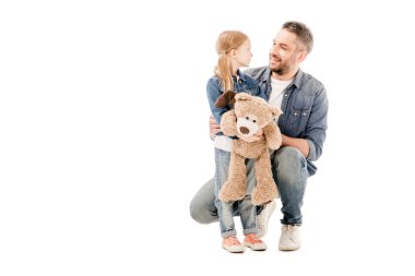gülümseyen baba ve kızı oyuncak ayı ile birbirlerine beyaz izole bakarak
