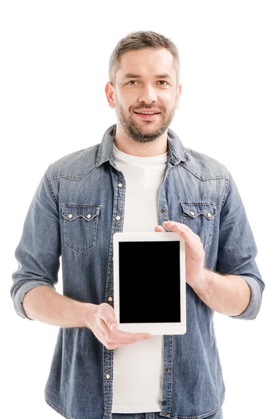 白で隔離された空白の画面を持つデジタルタブレットを保持するデニムシャツで笑顔のあごひげの男の正面図 — ストック写真