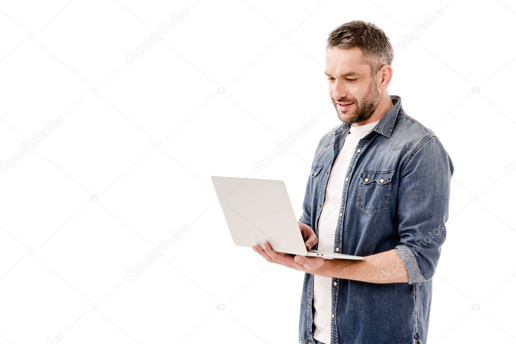 smiling man in denim shirt using laptop isolated on white