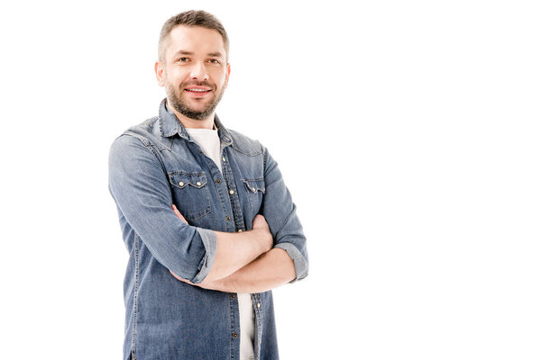 smiling bearded man in denim shirt standing with crossed arms isolated on white