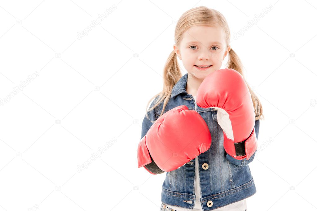 front view of smiling kid in red boxing gloves isolated on white