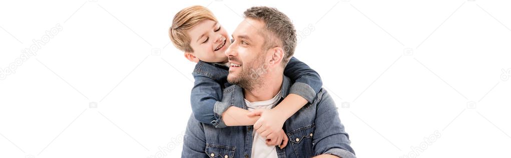 panoramic shot of smiling boy embracing father isolated on white