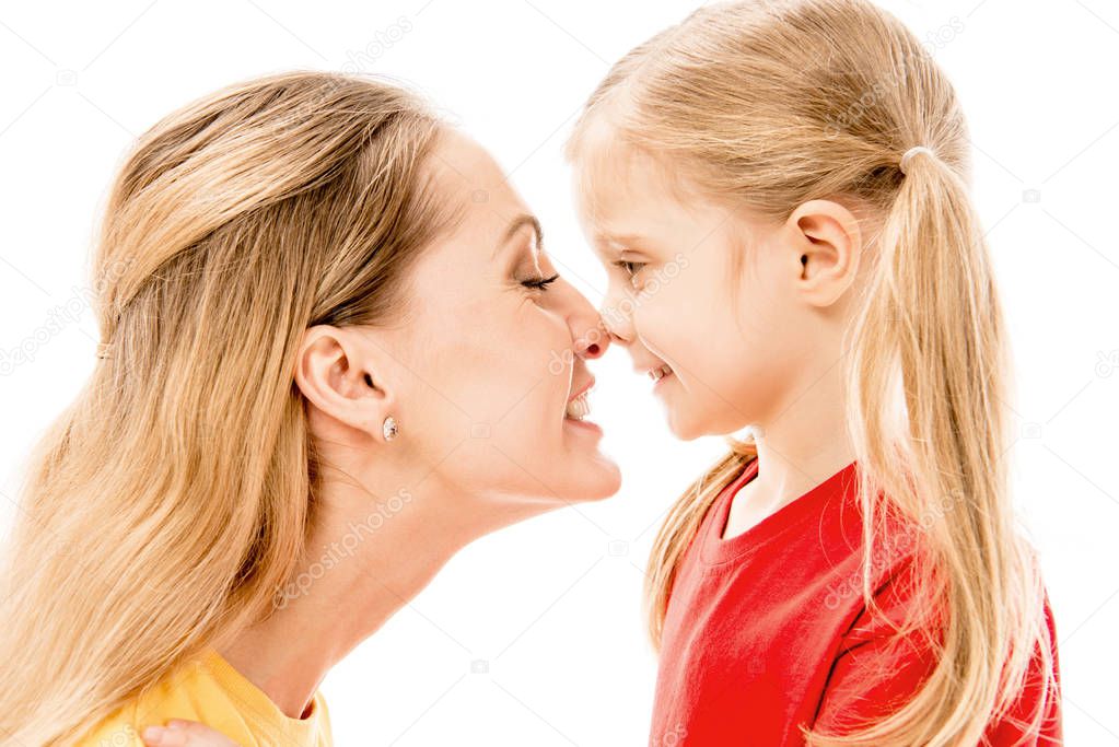 side view of happy mother and daughter touching noses isolated on white