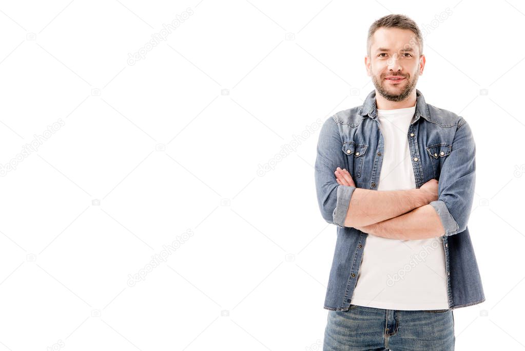 front view of smiling bearded man in denim shirt standing with crossed arms isolated on white