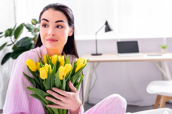 Retrato de mulher macia com buquê de tulipas amarelas em casa — Fotografia de Stock