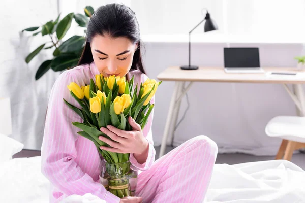 Retrato de mulher macia com buquê de tulipas amarelas em casa — Fotografia de Stock