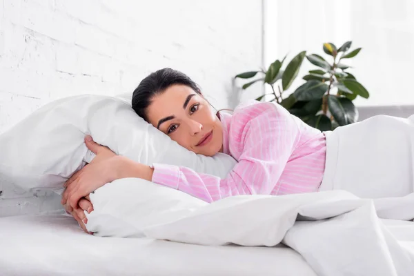 Portrait of woman in pink pajamas resting in bed in morning at home — Stock Photo