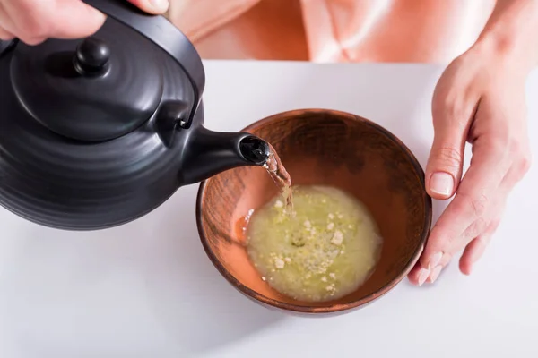 Abgeschnittene Aufnahme einer Frau, die Tee kocht, während sie morgens zu Hause Teezeremonie hat — Stockfoto