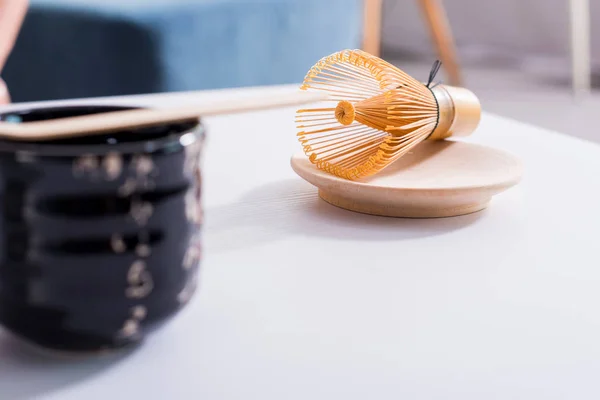 Close up view of arranged ceramic cutlery and whisk for tea ceremony on white tabletop — Stock Photo