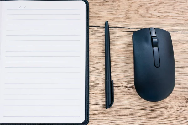 Top view of empty textbook, pen and computer mouse on wooden table — Stock Photo