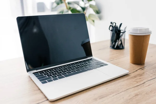Nahaufnahme von Laptop mit leerem Bildschirm, Kaffeetasse und Schreibwaren am Holztisch — Stockfoto