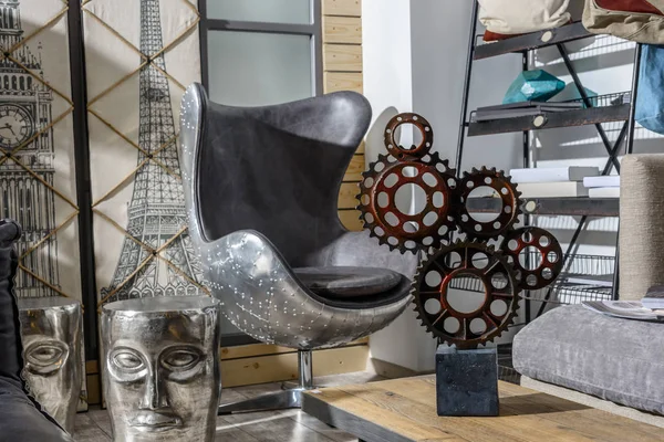 Intérieur du salon moderne de style rétro avec fauteuil gris, engrenages décoratifs et tête de personne — Photo de stock