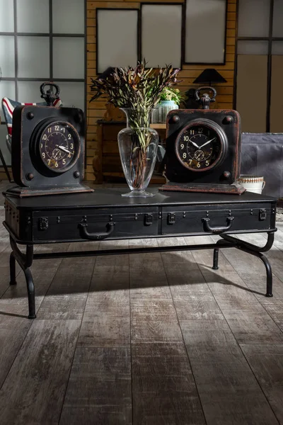 Interior de la moderna sala de estar de estilo retro con dos relojes y flores secas en la mesa - foto de stock