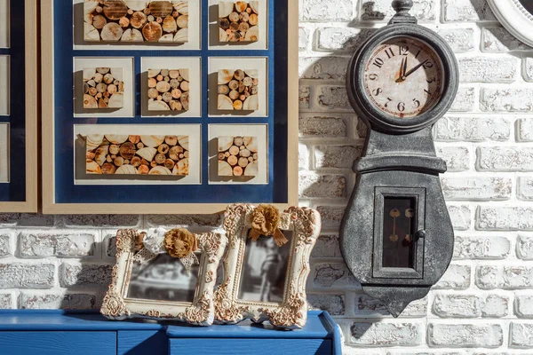 Photos dans les cadres et l'horloge sur le mur dans le salon moderne de style rétro — Photo de stock