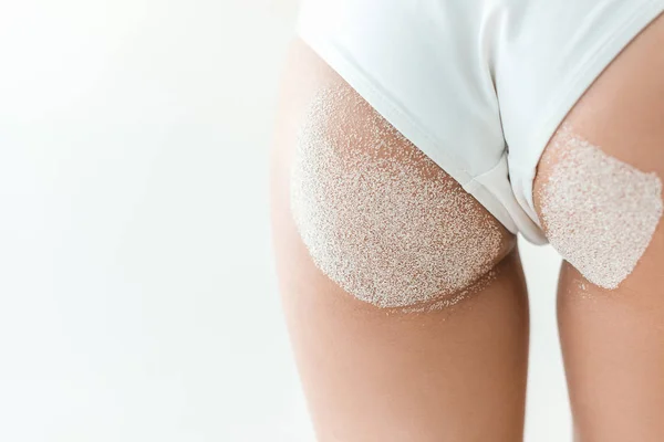 Vue partielle de belles fesses en bikini blanc avec sable, isolé sur blanc — Photo de stock
