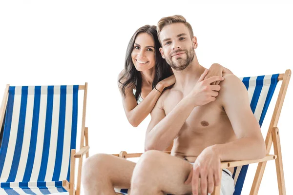 Jeune couple souriant embrassant et reposant sur des chaises de plage, isolé sur blanc — Photo de stock