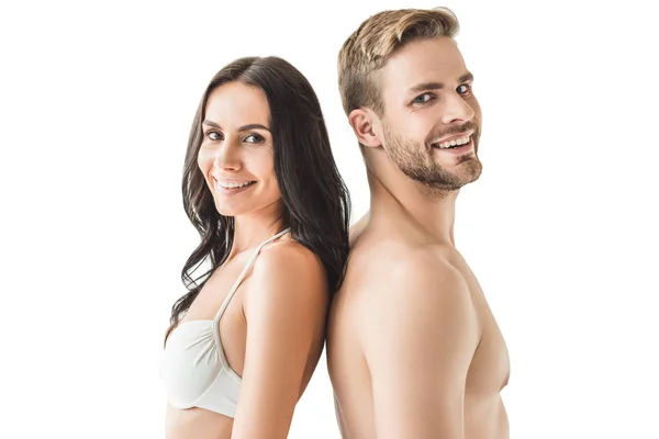 Heureux jeune couple debout dos à dos et regardant caméra, isolé sur blanc — Photo de stock