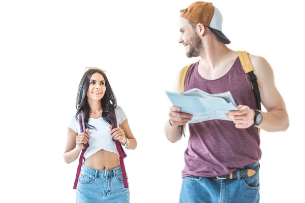 Couple de jeunes touristes avec sacs à dos avec carte et marche ensemble, isolé sur blanc — Photo de stock