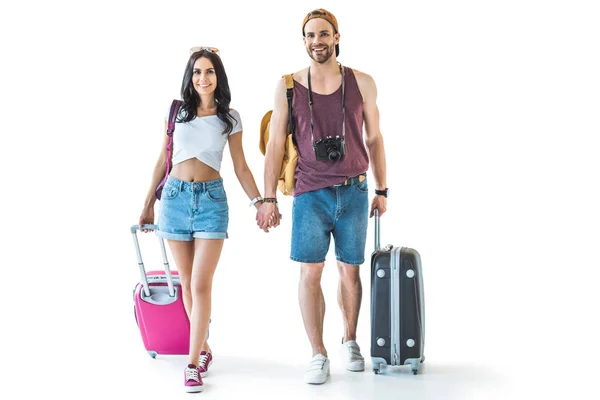 Pareja de jóvenes turistas con equipaje tomados de la mano, aislados en blanco - foto de stock