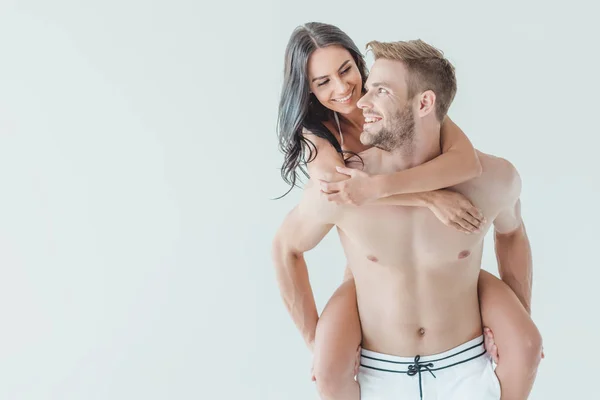 Bonito homem piggybacking seu feliz namorada, isolado no branco — Fotografia de Stock