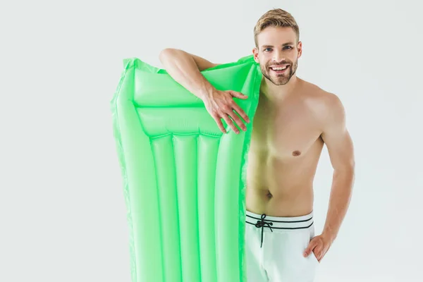 Bel homme souriant posant avec matelas gonflable, isolé sur blanc — Photo de stock