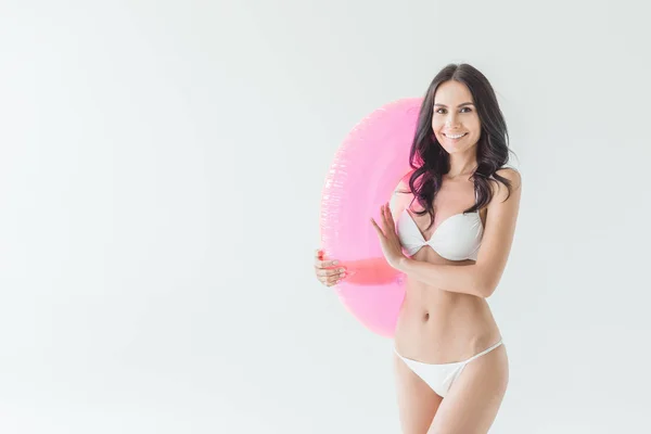 Belle femme souriante en bikini tenant cercle gonflable rose, isolé sur blanc — Photo de stock