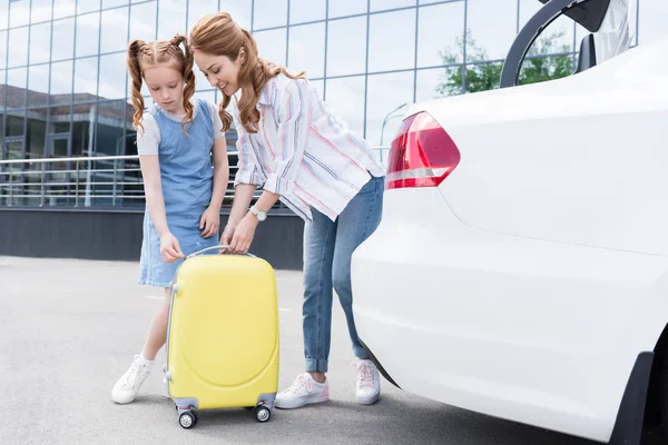 Famille avec bagages debout près de la voiture dans la rue — Photo de stock