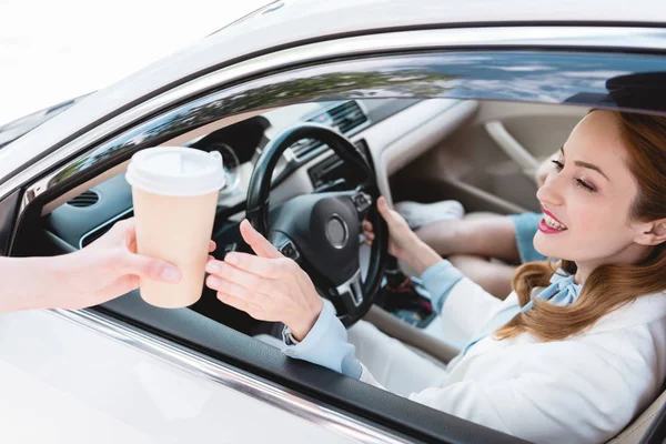 Donna d'affari sorridente in auto prendere il caffè per andare da commessa — Foto stock