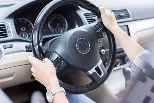 Vista parcial de la mujer con las manos en el volante de conducción del coche - foto de stock