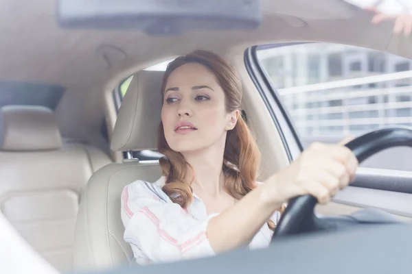 Retrato de mulher olhando para longe enquanto dirige carro — Fotografia de Stock